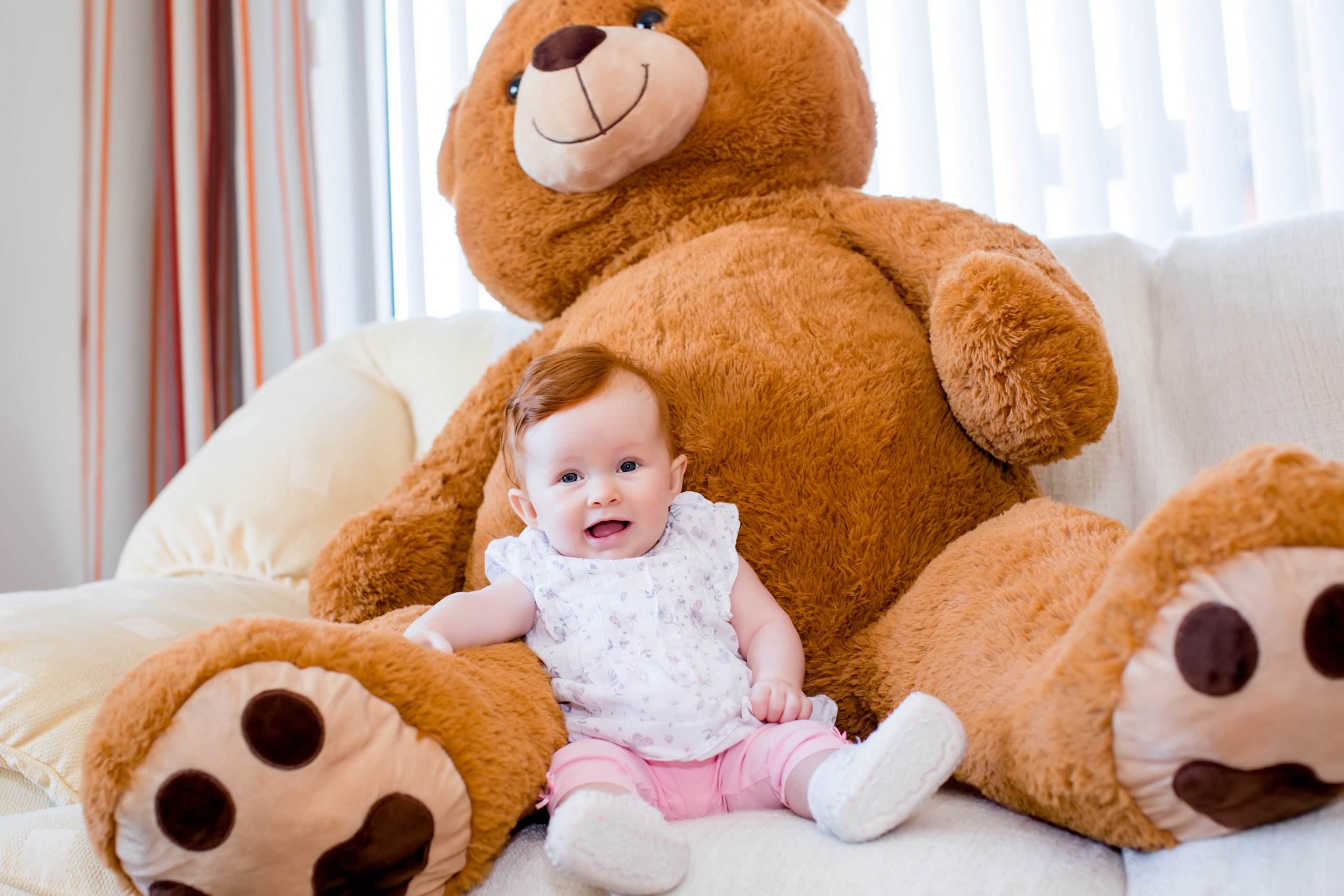 baby at home with giant teddy bear
